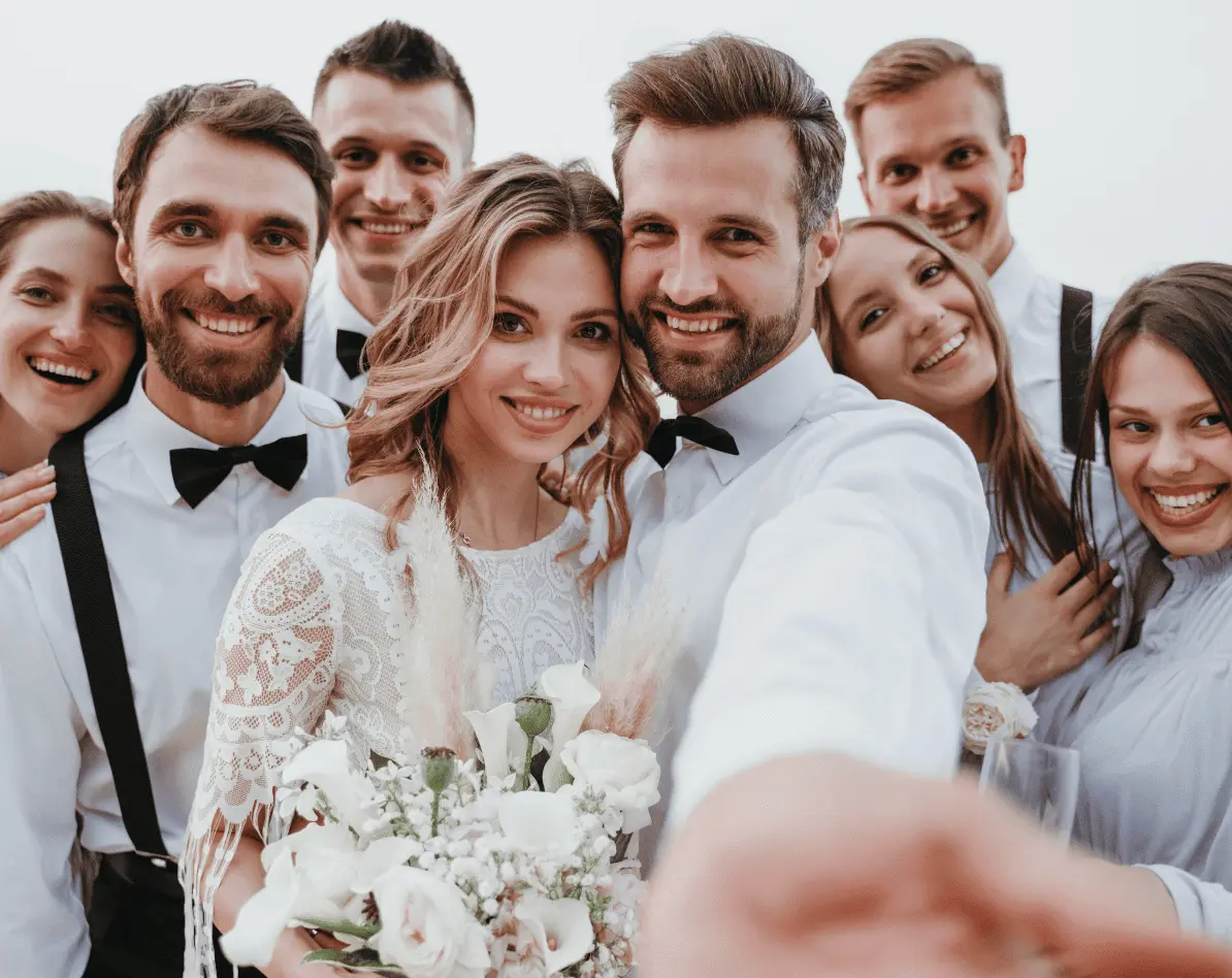 Couple de mariés en train de se prendre en photos avec leur amis