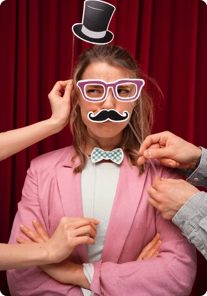femme devant un photobooth avec une moustache en déguisement