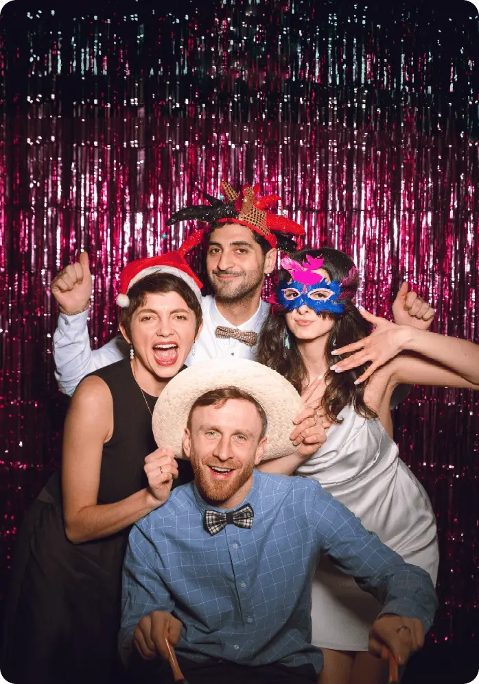 groupe d'amis devant un photobooth pendant un anniversaire